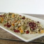 Nutritious quinoa salad bowl with colorful dried cranberries, apricots, fresh vegetables and pumpkin seeds, featuring ingredients available at The Greensted grocery store in downtown Zumbrota.